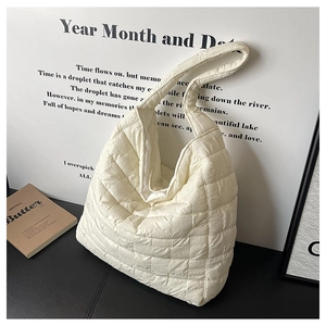 Détail du sac hobo matelassé crème avec texture rembourrée à carreaux sur fond moderne en cuir