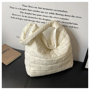 Vue détaillée du sac cabas matelassé crème avec texture à bulles sur surface en cuir