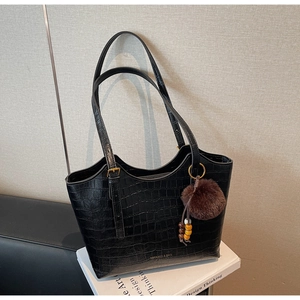 Detailed macro view of black crocodile pattern faux leather on a large tote bag
