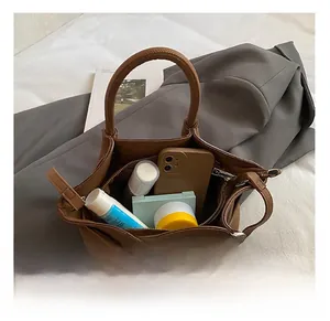 Detailed internal view of the brown bucket bag showing capacity for phone and cosmetics