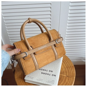 Détail d'un sac cabas en daim camel montrant les doubles anses et la texture