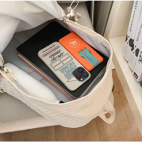 Detailed view of the striped canvas backpack interior showing spacious storage and pockets