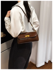 Detailed view of deep brown vintage leather underarm bag with gold chain strap