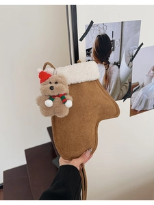 Detail der Weihnachtssocken-Tasche mit Plüschbär-Anhänger und Lammfell-Besatz
