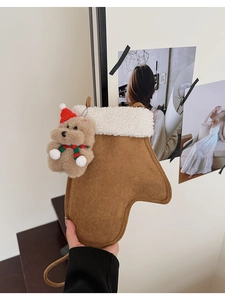 Detail der Weihnachtsstrumpf-Tasche aus Wildleder mit weißem Fleece und Teddybär-Anhänger