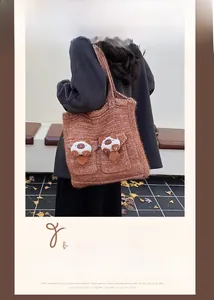 Outdoor shot of caramel large knit tote bag with decorative pockets and cute charms