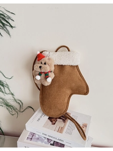 Detail einer braunen Weihnachtsstrumpf-Tasche aus Wildlederimitat mit Teddy-Anhänger