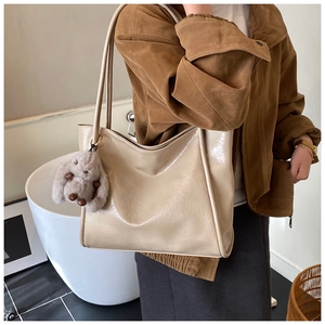 Beige tote bag with crinkle texture and cute bunny pendant shown in lifestyle setting