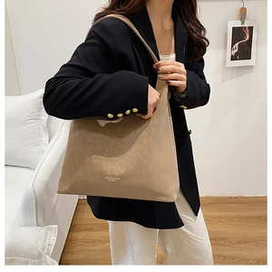 Detail der taupefarbenen Shopper-Tasche aus Mattleder mit Markenlogo und breitem Riemen