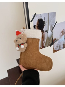 Detail eines Wildleder-Weihnachtsstrumpfs mit weißem Fleecefutter und Plüsch-Hundeanhänger