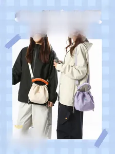 Detail view of nylon drawstring crossbody phone bags in cream and lavender colors