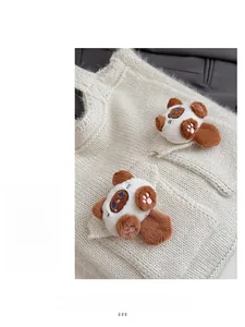 Detail of off-white knit shoulder bag featuring cute plush panda charms on the pocket