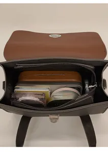Interior view of vintage shoulder bag showing storage capacity for phone and cosmetics