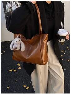 Detail of caramel large soft faux leather tote bag with plush bunny pendant charm
