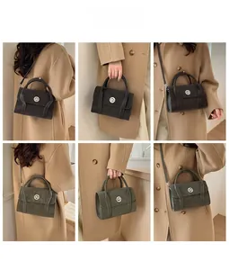 Close-up of retro square crossbody bag with metallic twist lock and smooth top handle