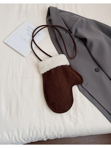 Detail der braunen Umhängetasche in Handschuhform aus Wildlederimitat mit Lammfellbesatz