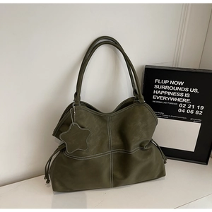 Detail view of army green tote bag with contrast stitching and star charm accessory