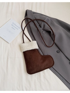 Detail der stiefelförmigen Wildledertasche mit weißem Lammfellbesatz und Kordelzug-Schultergurt