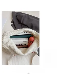 Top view of cream white knit tote bag showing spacious interior with books and gadgets