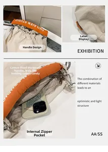 Detail of soft padded orange handles and interior zipper pocket of the tote bag