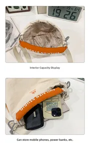 Detail view of large cream canvas tote bag interior with logo lining and storage capacity
