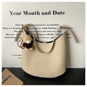 Détail du sac hobo blanc cassé en cuir grainé avec un pendentif ours en peluche