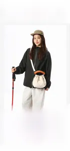 Asian model carrying a cream tote bag with orange handles in a hiking scenery