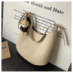 Détail du sac hobo beige avec texture cuir galet et charmant ours en peluche