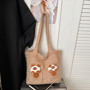 Detail of khaki knitted tote bag featuring cute 3D cat dolls and textured knit fabric