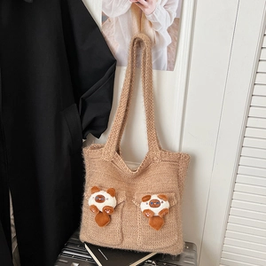 Macro detail of camel knit tote bag with plush animal charms and double front pockets