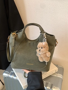 Deep green retro bucket bag with gold lettering, shoulder strap and bear charm