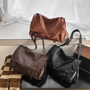 Three retro messenger bags in brown and black displayed on a white windowsill scene