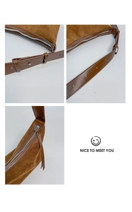 Détail du sac à bandoulière en daim marron montrant la sangle réglable et la boucle argent