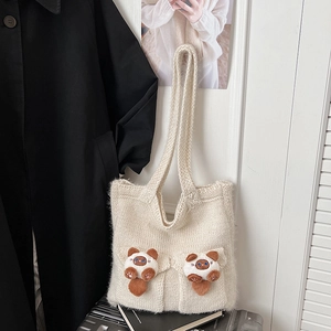 Close-up of cream knit shoulder bag featuring cute 3D cat pockets and thick woven texture