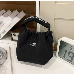 Detail of black canvas tote bag with thick padded handles and stylish drawstring closure