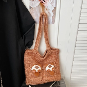 Close-up of caramel knit shoulder bag with cute plush cat dolls and dual pockets