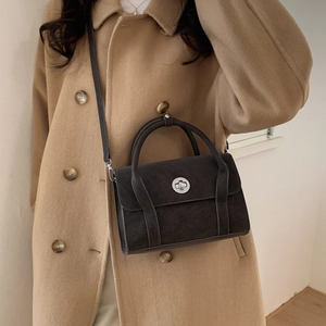 Detailed macro view of dark grey matte synthetic leather bag with silver metal swivel lock