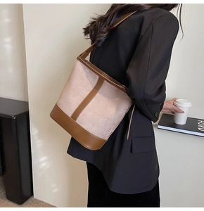 Detail of minimalist two-tone suede bucket bag with leather straps and large capacity