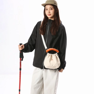 Outdoor style off-white drawstring bucket bag with orange branded handle and tote detail