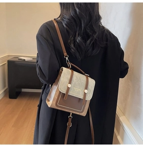 Detail of retro contrasting faux leather backpack with metallic rivets and white lettering