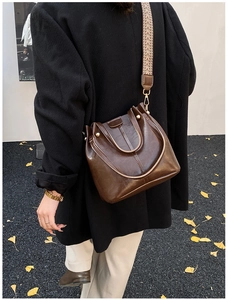 Detailed view of vintage dark brown bucket bag with geometric patterned wide strap