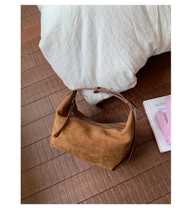 Detail of soft brown suede texture on the crescent hobo bag with zipper and leather strap