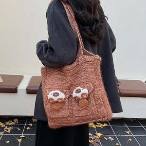 Caramel knit tote bag with plush cat pockets shown on model for autumn fashion