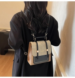 Close-up of a vintage tricolor leather backpack worn by a model in a warm interior