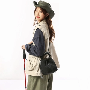 Detail of black drawstring nylon crossbody bag for outdoor hiking and sports utility