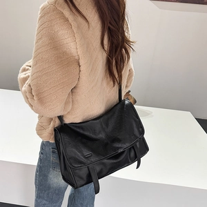 Minimalist black leather messenger bag shown on model for a casual and stylish fit