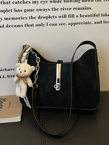 Minimalist black suede shoulder bag with silver horseshoe buckle and bear pendant