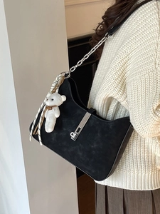 Minimalist black suede underarm bag with silver chain strap and plush bear charm