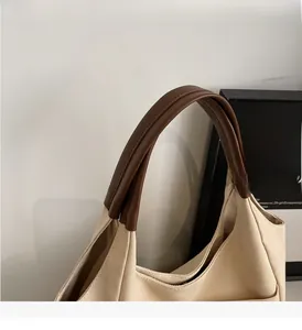 Detail view of durable beige canvas tote bag with sturdy brown leather handles