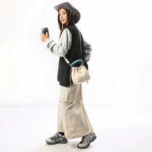 Detail of canvas bucket bag featuring blue circular handles and shilaien studio logo